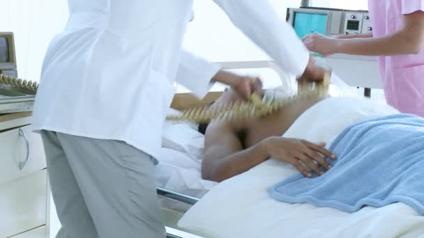 Médecin et infirmière réanimant un patient avec un défibrillateur et un masque — Video