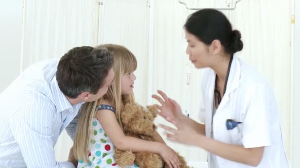 Doctora hablando con una niña y su padre — Vídeo de stock