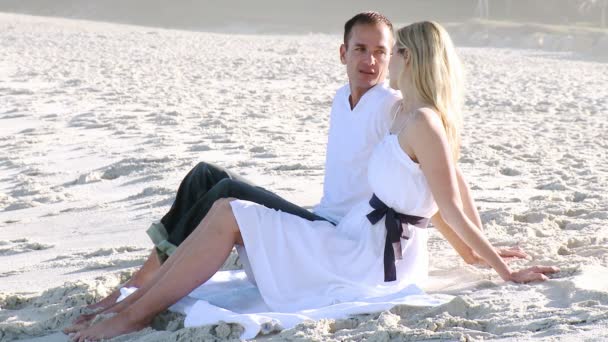 Man and woman relaxing on the beach during the day — Stock Video