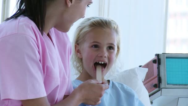 Infermiera controllando una gola ragazzine in ospedale — Video Stock