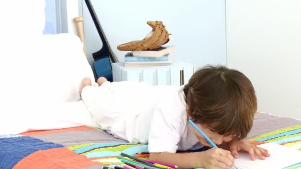 Sorrindo menino desenho na cama — Vídeo de Stock