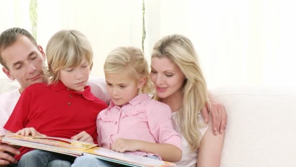 Happy family reading on the sofa — Stock Video