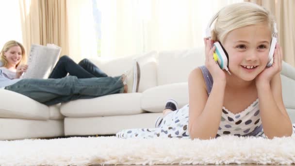 Beautiful little girl listening to the music in the living-room — Stockvideo