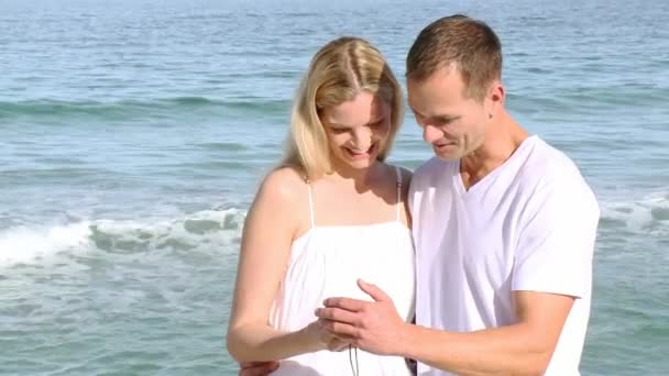 Close-up of couple on the beach watching photos — Stock Video