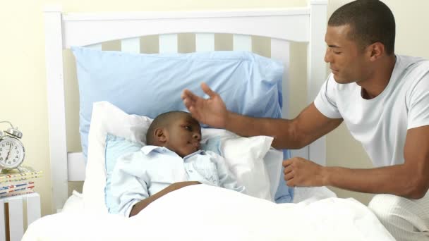 Tata etnic ia temperatura fiului în dormitor — Videoclip de stoc
