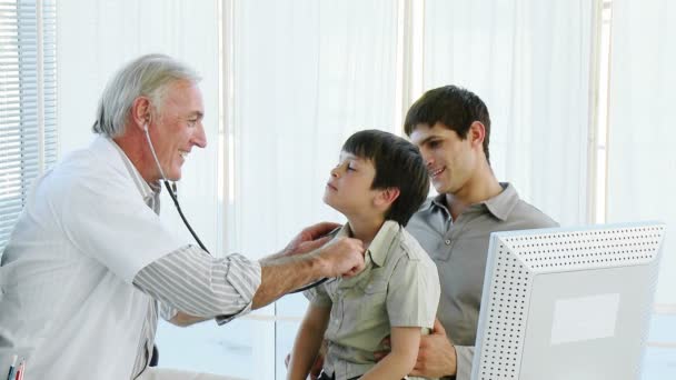 Старший врач слушает ребенка со стетоскопом — стоковое видео