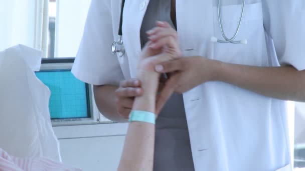 Close-up of doctor taking senior woman's pulse — Stock Video