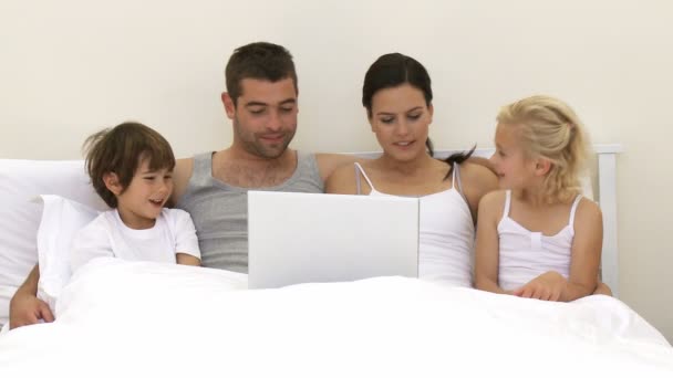Família usando um laptop na cama — Vídeo de Stock