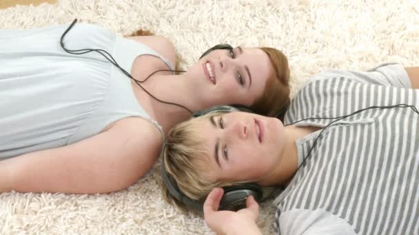 Teenage Couple listening to music while relaxing — Stock Video