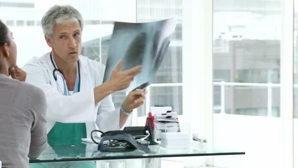 Maturo medico e il suo paziente esaminando una radiografia — Video Stock