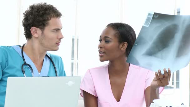 Seriöse Ärzte untersuchen ein Röntgenbild — Stockvideo