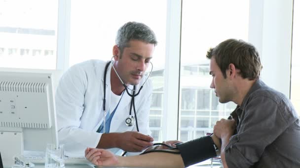 Médico masculino examinando a un paciente — Vídeo de stock