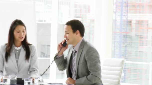 Амбициозная команда бизнесменов звонит по телефону на встрече — стоковое видео