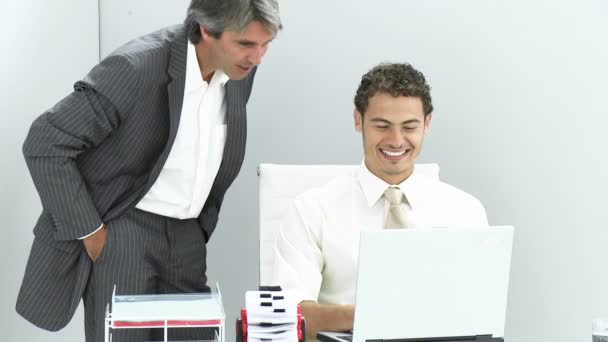 Dos hombres de negocios encantadores trabajando en una computadora portátil — Vídeo de stock