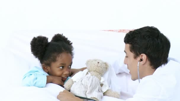 Jeune médecin parlant avec une petite fille — Video