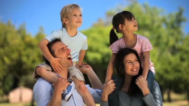 Padres llevando a sus hijos y disfrutando del tiempo juntos — Vídeos de Stock