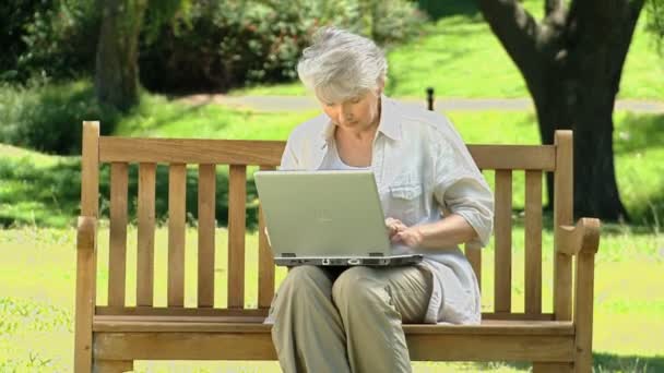 Seniorin schaut auf Laptop — Stockvideo