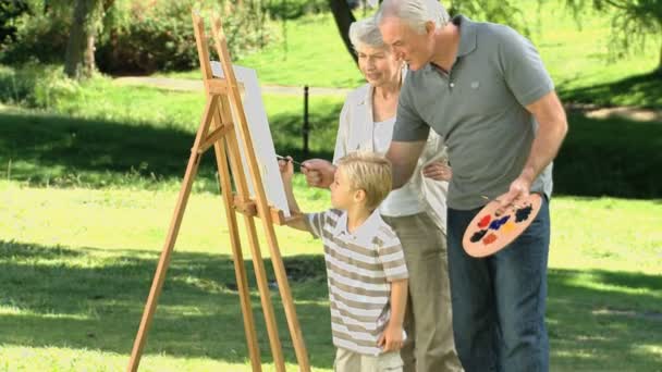 Abuelos y nieto pintando un lienzo — Vídeos de Stock