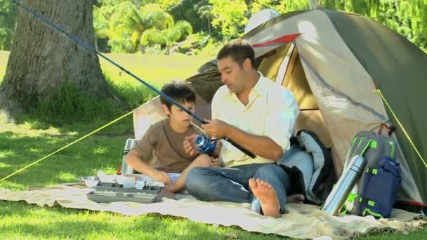 Pai ensinando o uso da vara de pesca para seu filho — Vídeo de Stock