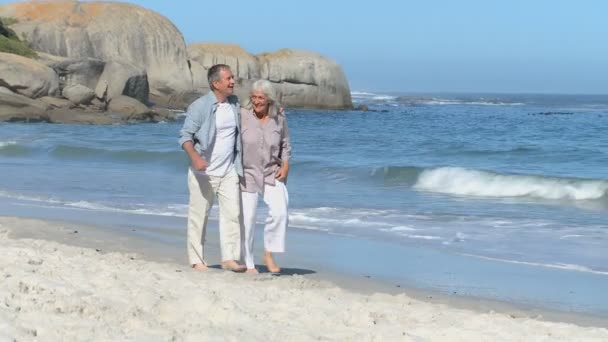 Äldre par promenader längs stranden — Stockvideo