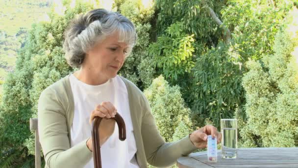 Беспокойная старуха смотрит свои таблетки — стоковое видео