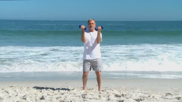 Homme âgé travaillant ses muscles avec des haltères — Video