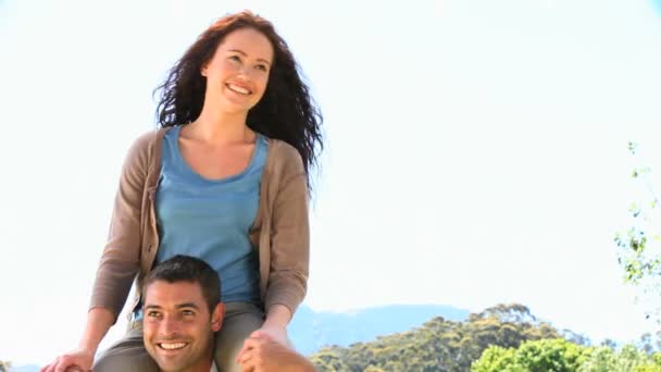 Netter Mann trägt seine Frau auf seinen Schultern — Stockvideo
