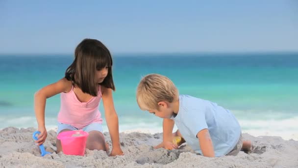 Barn som bygger ett sandslott — Stockvideo