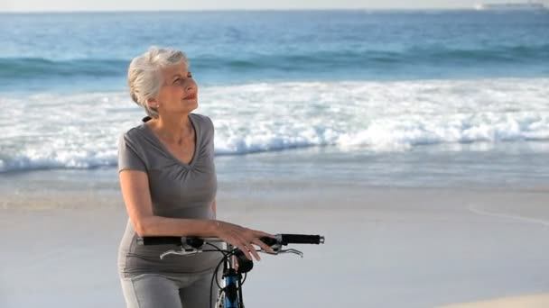 Mujer anciana esperando con una bicicleta — Vídeo de stock