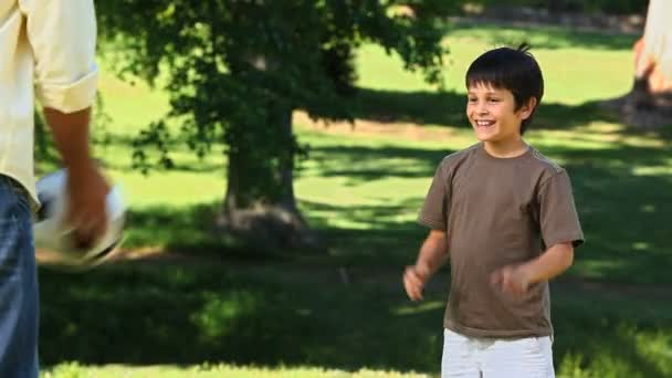 Vader en zoon spelen met een bal — Stockvideo