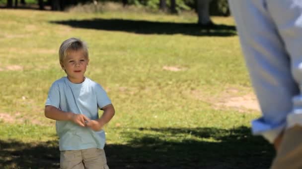 Pai e seu filho brincando com uma bola de futebol — Vídeo de Stock