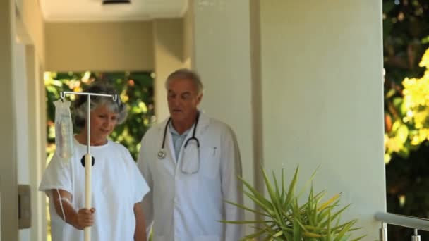 Médecin et patient marchant dans le pont — Video