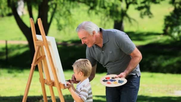 Niño pintando un lienzo blanco con el abuelo — Vídeo de stock