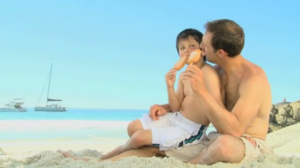 Père et fils mangeant de la glace — Video