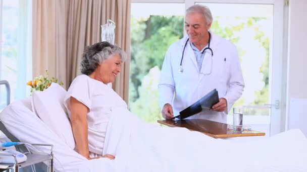 Doutor mostrando um raio-x para seu paciente — Vídeo de Stock