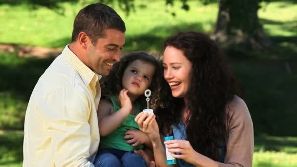 Chica disfrutando de burbujas con sus padres — Vídeo de stock