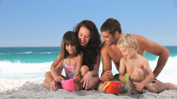 Familia jugando con la arena — Vídeos de Stock