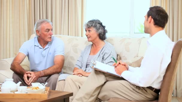 Casal velho conversando com um comercial — Vídeo de Stock