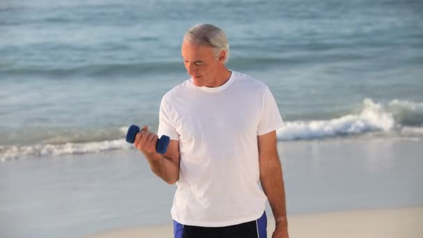 Senior man working his muscles with dumbbells — Stock Video