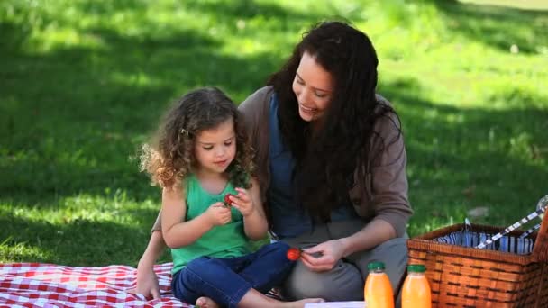 Maman et fille appréciant les fraises assis sur la nappe — Video