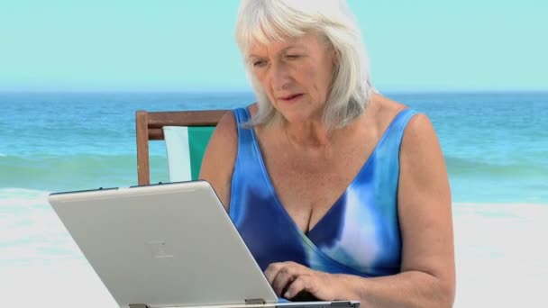 Oudere vrouw chatten op haar laptop — Stockvideo