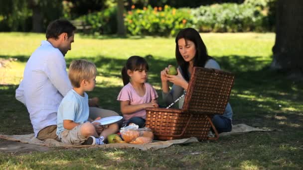 Eltern genießen ein Picknick mit Kindern auf einer Tischdecke — Stockvideo