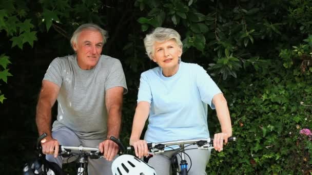 Casal de idosos caminhando com suas bicicletas — Vídeo de Stock