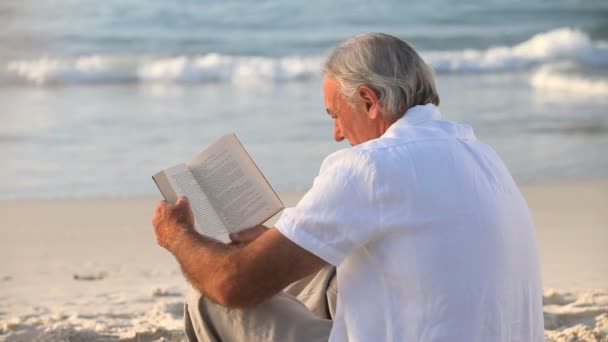 Homme âgé lisant un livre — Video