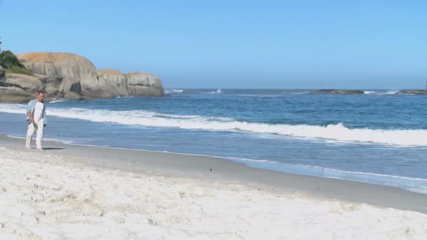 Leeftijd man lopen langs het strand — Stockvideo