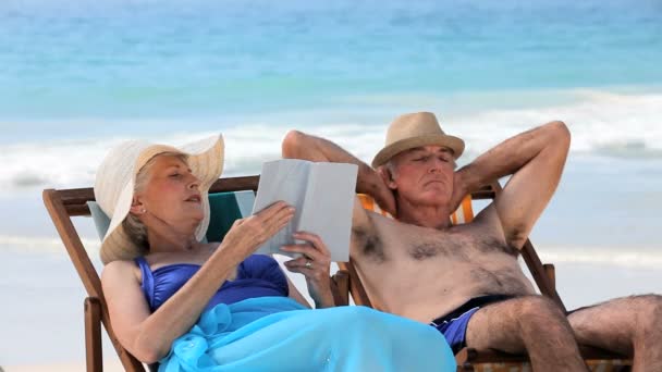 Casal idoso relaxante em cadeiras de praia — Vídeo de Stock
