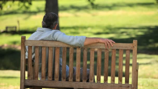 Vieil homme relaxant sur un banc — Video