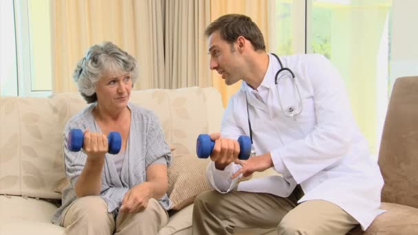 Arzt zeigt seinem Patienten die Verwendung von Kurzhanteln — Stockvideo