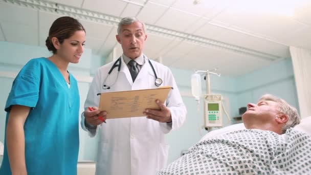 Doctor and a nurse looking at medical chart in a hospital — Stock Video