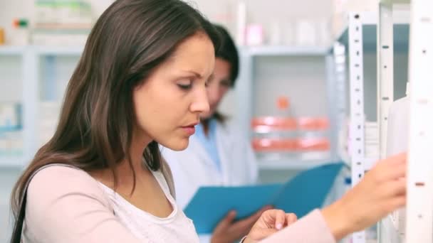 Kunde in einer Apotheke mit einer Flasche Drogen — Stockvideo